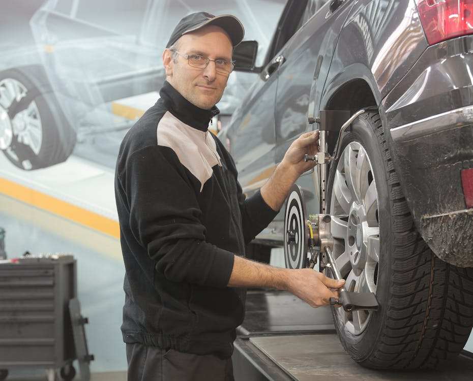 Technician performing vehicle wheel alignment at Hevtech Mechanic & Tire Services.